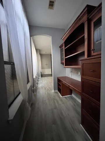 a hallway view with wooden floor and staircase