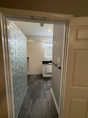 a bathroom with a granite countertop shower and a sink