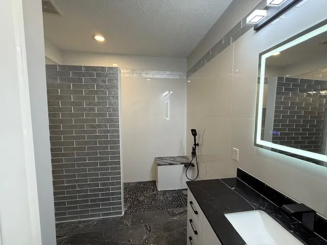 a bathroom with a granite countertop sink toilet and shower