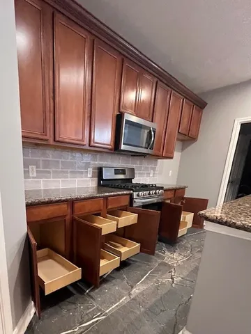 a kitchen with stainless steel appliances granite countertop a sink stove and refrigerator