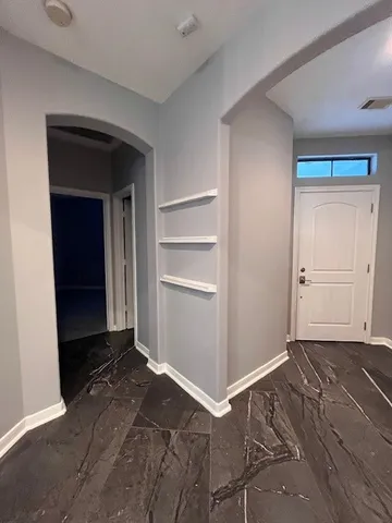a view of an empty room with closet and a window