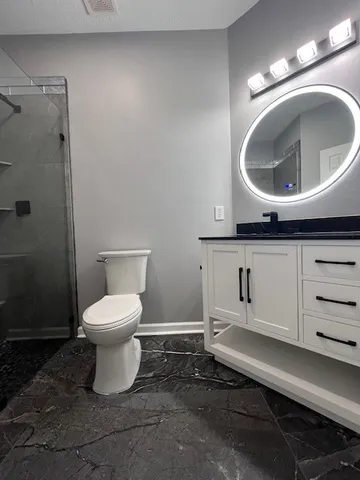 a bathroom with a toilet sink and mirror
