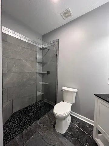 a bathroom with a toilet and a shower