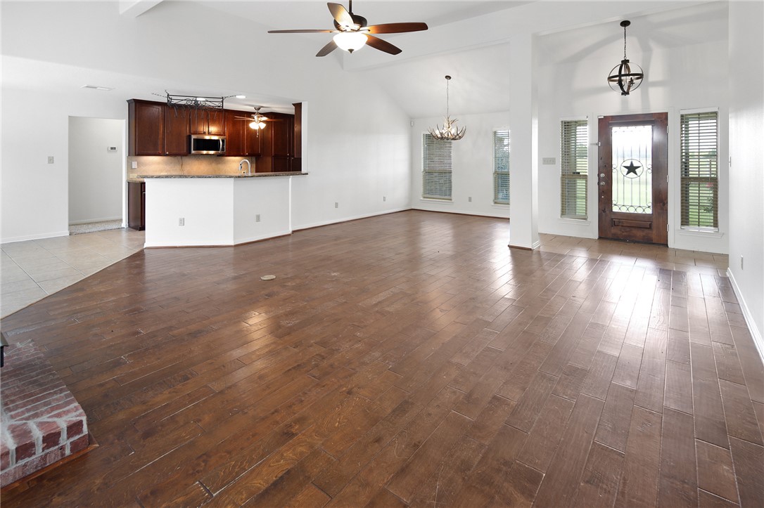 7808 Oxford Cemetery Road Madisonville, TX 77864 - Photo 24 of 41 a view of a livingroom with a flat screen tv wooden floor and a chandelier fan
