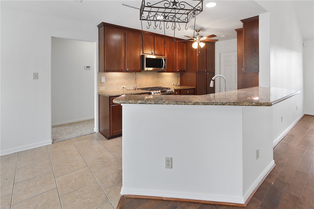 7808 Oxford Cemetery Road Madisonville, TX 77864 - Photo 26 of 41 a kitchen with stainless steel appliances granite countertop a sink and a stove