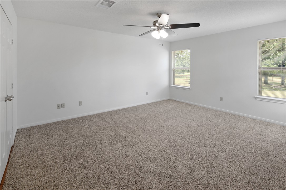 7808 Oxford Cemetery Road Madisonville, TX 77864 - Photo 30 of 41 Carpeted spare room with a ceiling fan and a textu