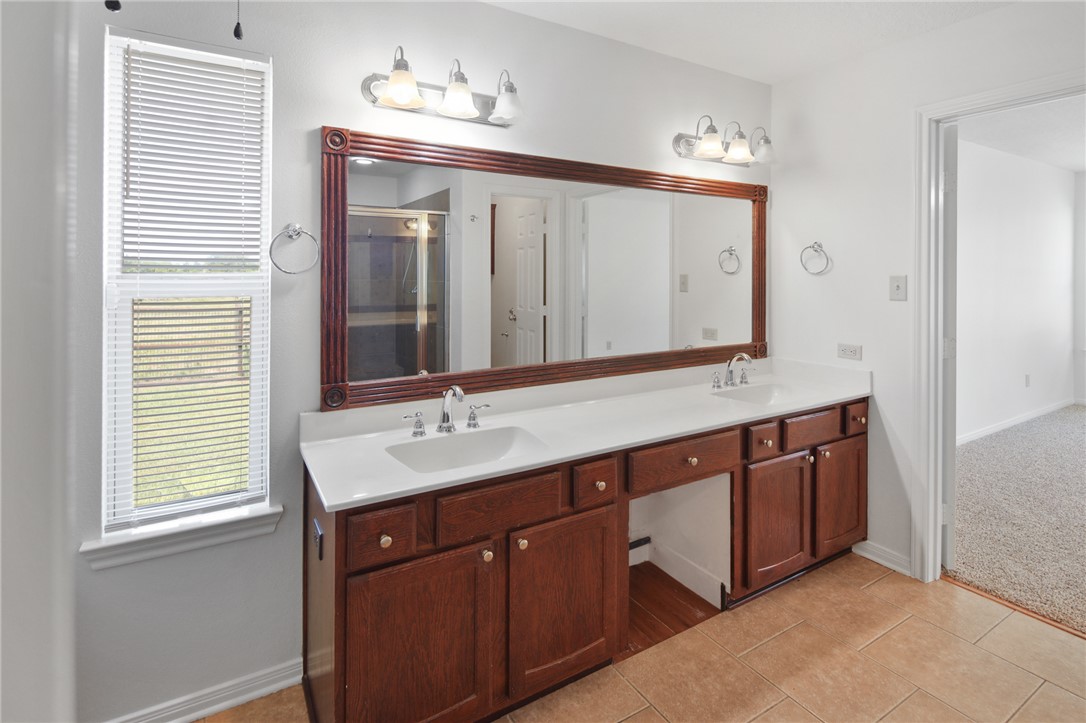 7808 Oxford Cemetery Road Madisonville, TX 77864 - Photo 33 of 41 a bathroom with a double vanity sink and a mirror