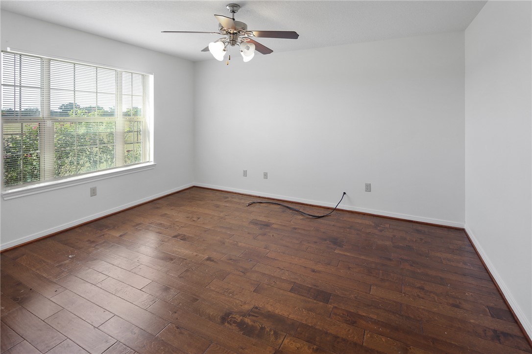 7808 Oxford Cemetery Road Madisonville, TX 77864 - Photo 35 of 41 an empty room with wooden floor fan and windows
