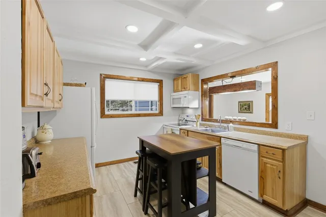 a kitchen with stainless steel appliances a sink a stove a refrigerator cabinets and dining table