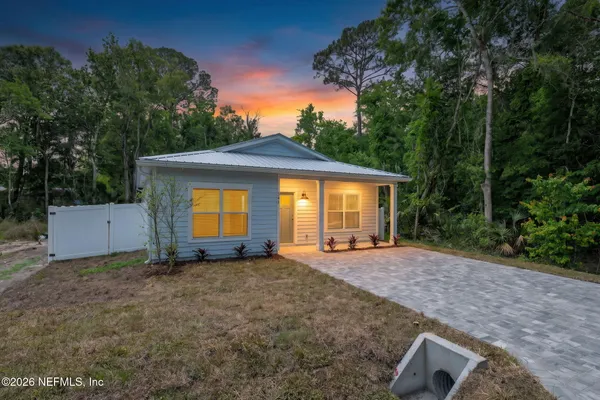 a view of a house with a yard and tree