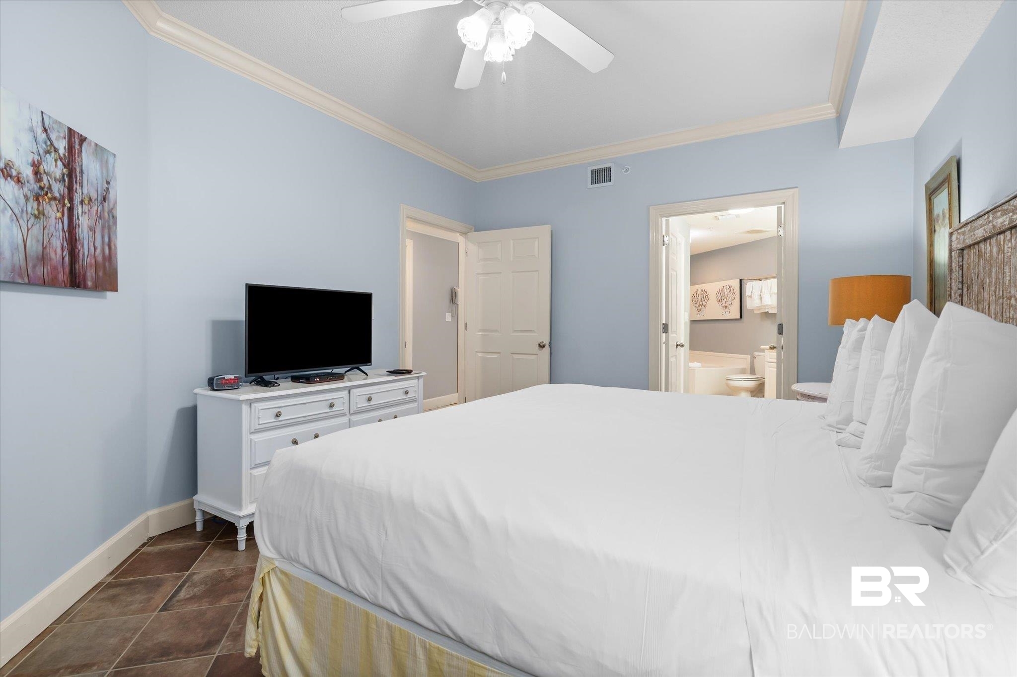 27580 Canal Road, Unit 1423 Orange Beach, AL 36561 - Photo 11 of 34 Primary bedroom featuring dark tile patterned floors, ornamental molding and ensuite bathroom