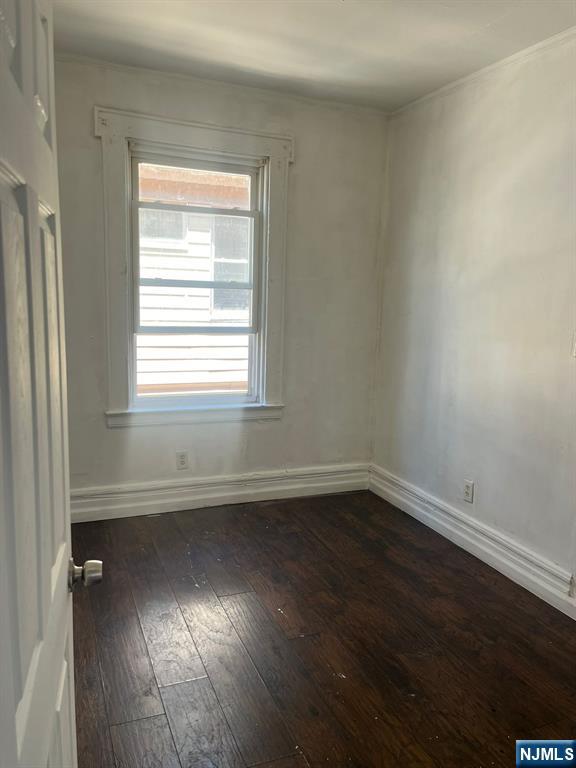 281 Renner Avenue, Unit 279 Newark, NJ 07112 - Photo 6 of 12 an empty room with wooden floor and windows