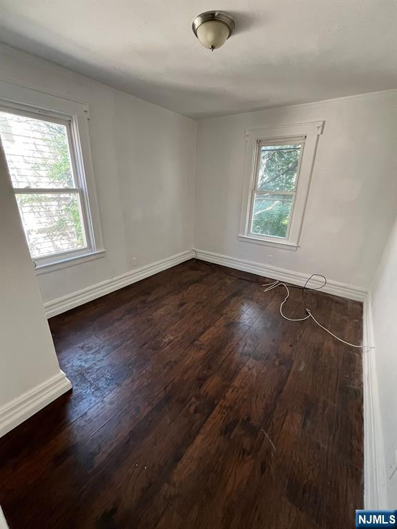 281 Renner Avenue, Unit 279 Newark, NJ 07112 - Photo 7 of 12 an empty room with wooden floor and windows