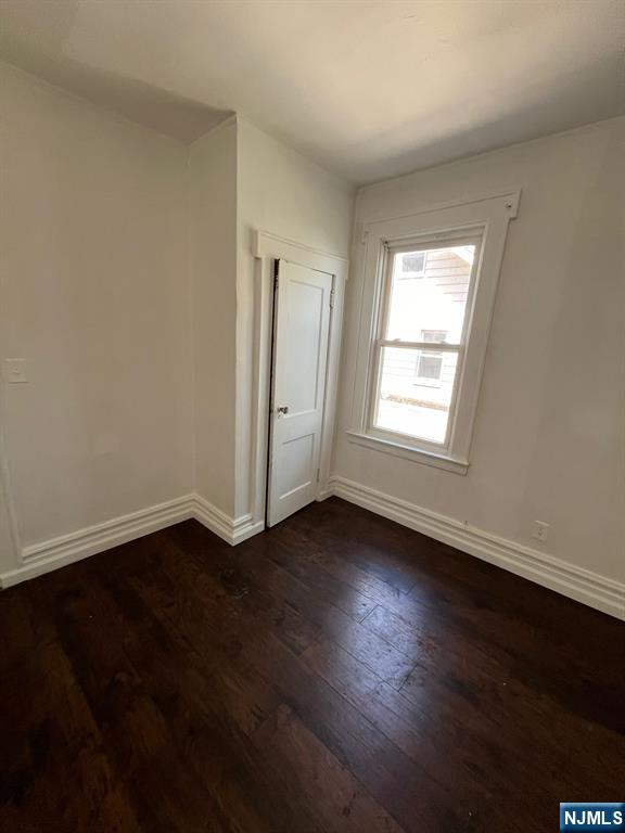 281 Renner Avenue, Unit 279 Newark, NJ 07112 - Photo 8 of 12 a view of an empty room with wooden floor and a window