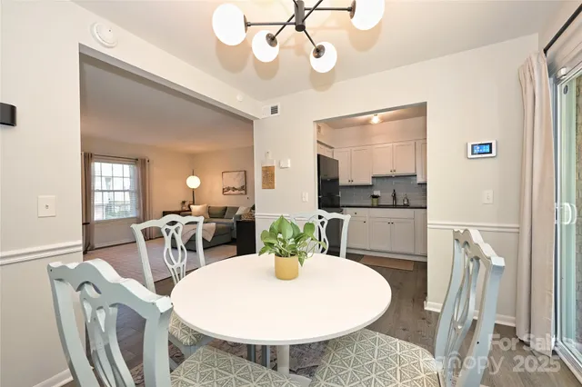 a dining room with furniture a chandelier and wooden floor