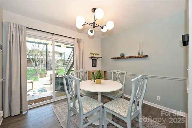 a dining room with wooden floor a chandelier a glass table and chairs