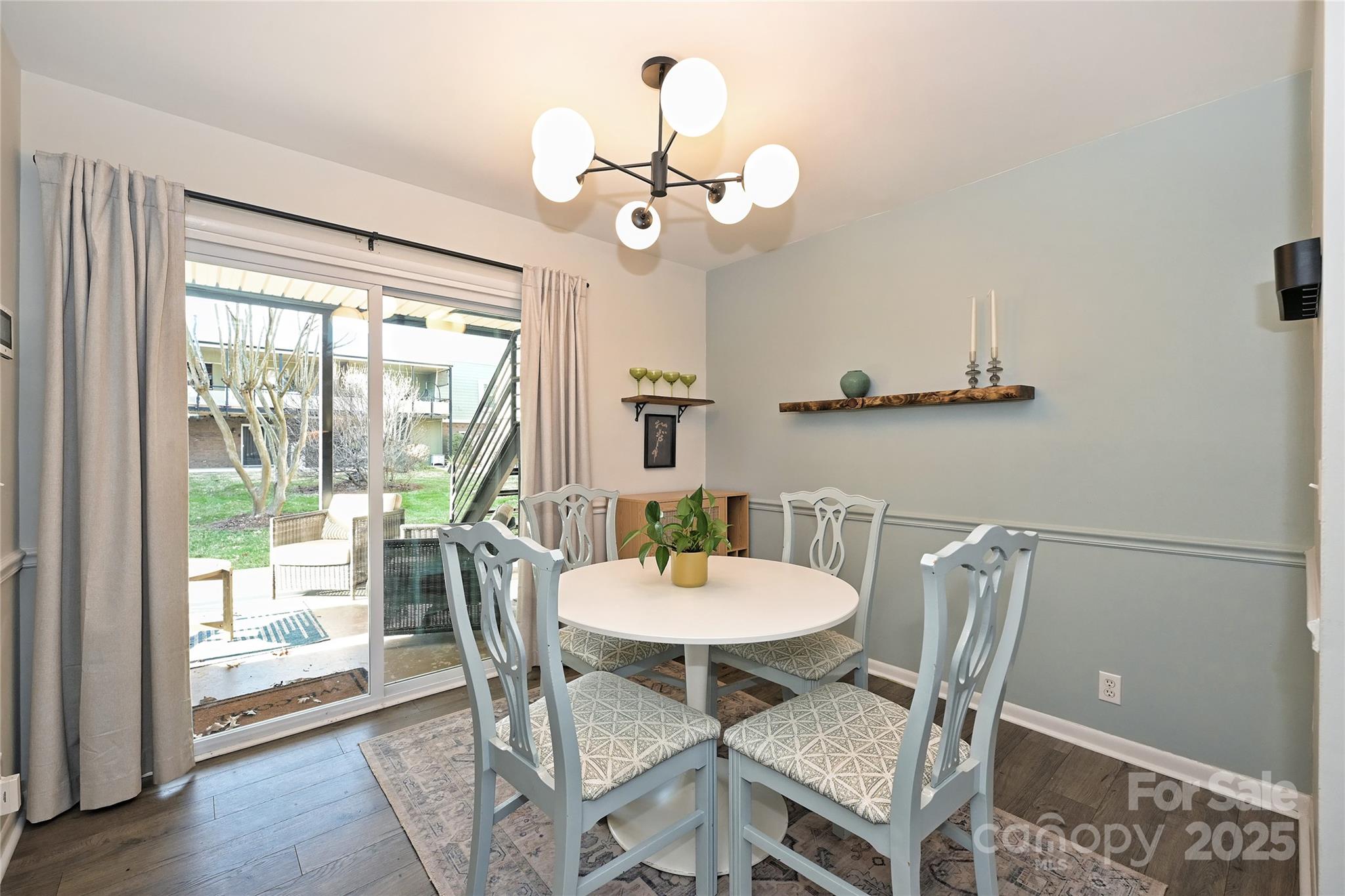 2604 Park Road, Unit B Charlotte, NC 28209 - Photo 8 of 21 a dining room with wooden floor a chandelier a glass table and chairs