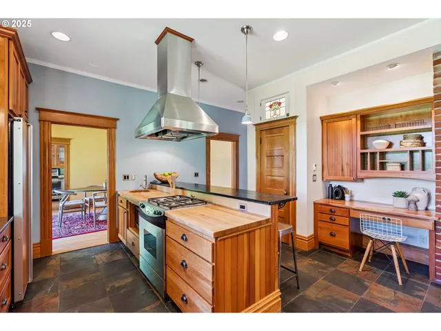 a kitchen that has a stove a table and chairs in it