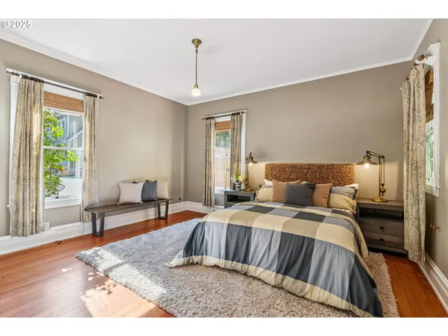 a bedroom with a bed and wooden floor