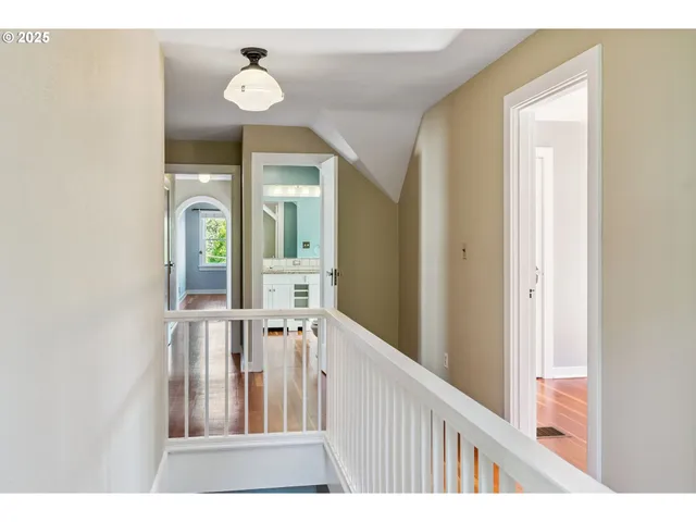 a view of a hallway with entryway wooden floor and cabinet