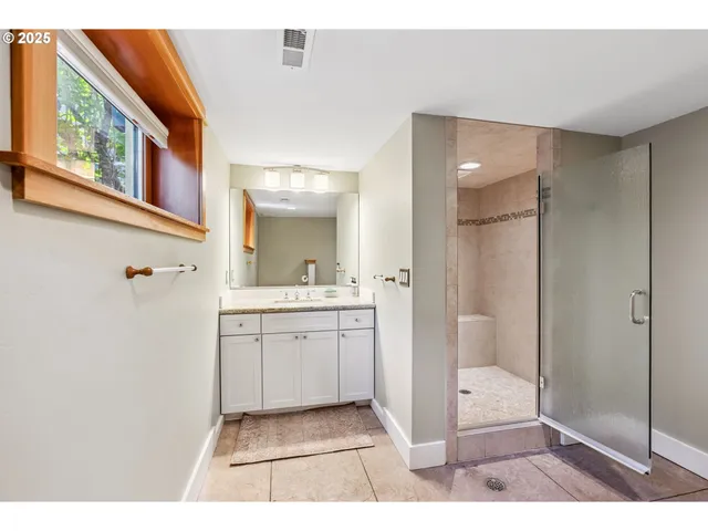 a bathroom with a shower a sink and a mirror