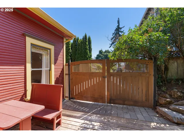 a view of backyard with wooden fence and large trees