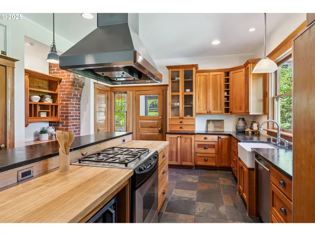 a kitchen with stainless steel appliances kitchen island granite countertop a stove a sink dishwasher and a dining table with granite countertops
