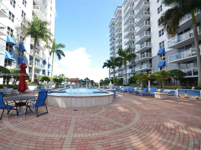 a view of a patio with a table and chairs under an umbrella