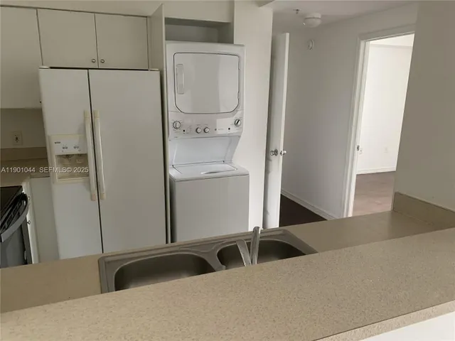 a kitchen with a refrigerator and white cabinets