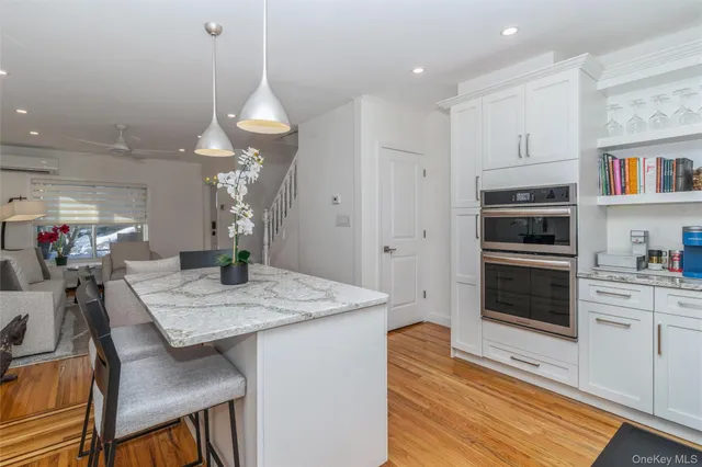 a kitchen with a stove a refrigerator and a dining table with wooden floor