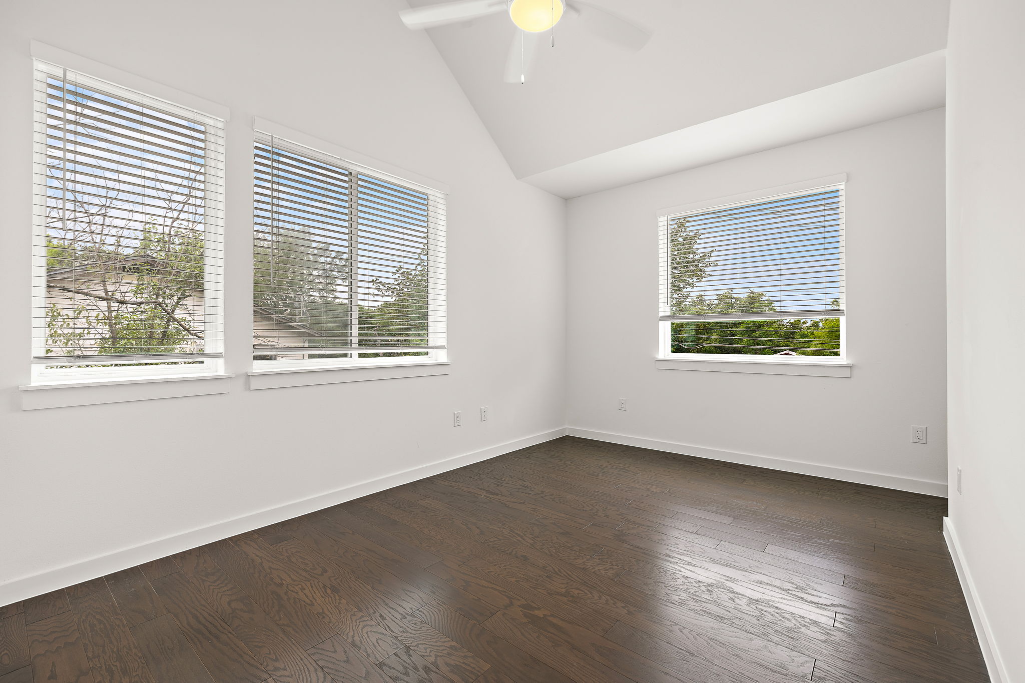 1206 Sarabeth Way Austin, TX 78721 - Photo 20 of 27 Unfurnished room featuring dark wood finished floors, ceiling fan, vaulted ceiling, and baseboards