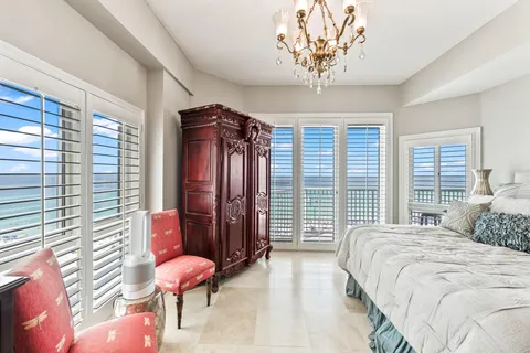 a living room with furniture kitchen view and a chandelier