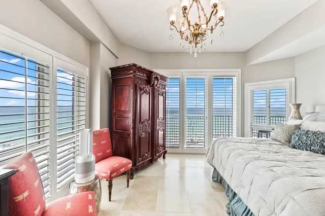 a living room with furniture kitchen view and a chandelier