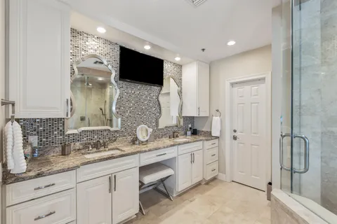 a bathroom with a granite countertop sink a toilet and a shower