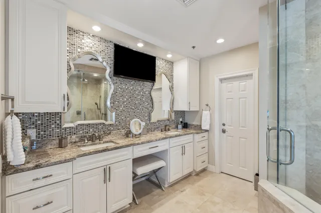a bathroom with a granite countertop sink a toilet and a shower