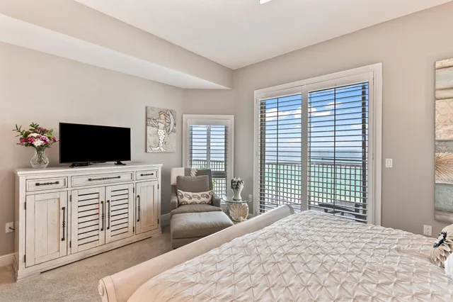a living room with furniture a flat screen tv and a chandelier