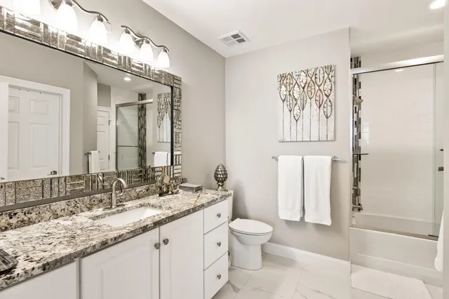 a bathroom with double vanity and a mirror