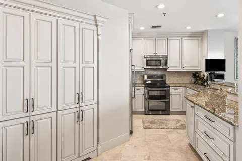 a kitchen with stainless steel appliances granite countertop a sink stove and cabinets