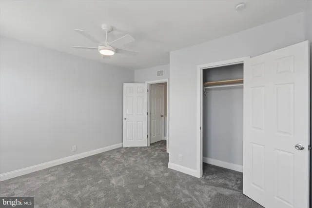 a view of an empty room with a ceiling fan