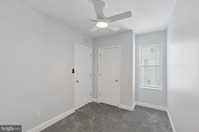 an empty room with a ceiling fan and closet