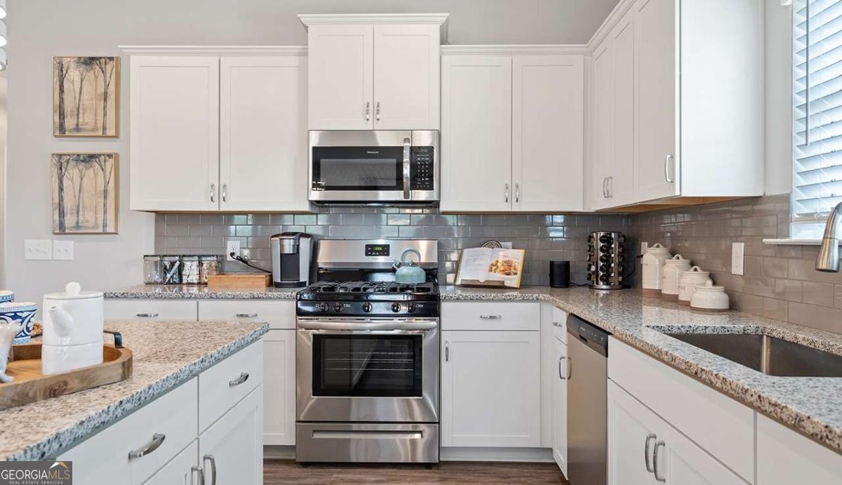 230 Shantz Way Byron, GA 31008 - Photo 12 of 16 a kitchen with stainless steel appliances granite countertop a sink a stove and a granite counter tops