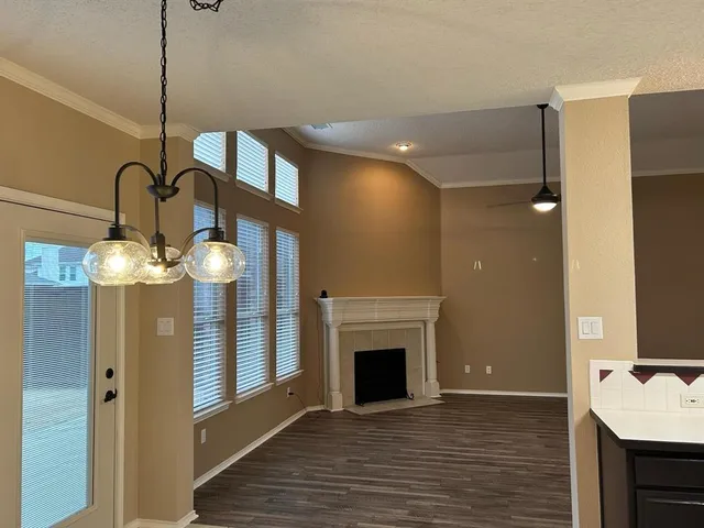 a view of a livingroom with a fireplace a chandelier and wooden floor
