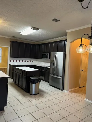 a kitchen with stainless steel appliances a stove a sink a refrigerator and cabinets