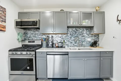 a kitchen with white cabinets stainless steel appliances and sink