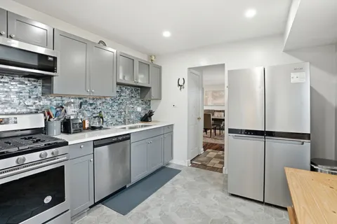 a kitchen with white cabinets and white appliances