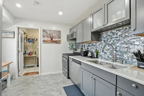a kitchen with stainless steel appliances granite countertop a sink and a refrigerator