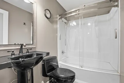 a bathroom with a granite countertop sink a toilet and shower