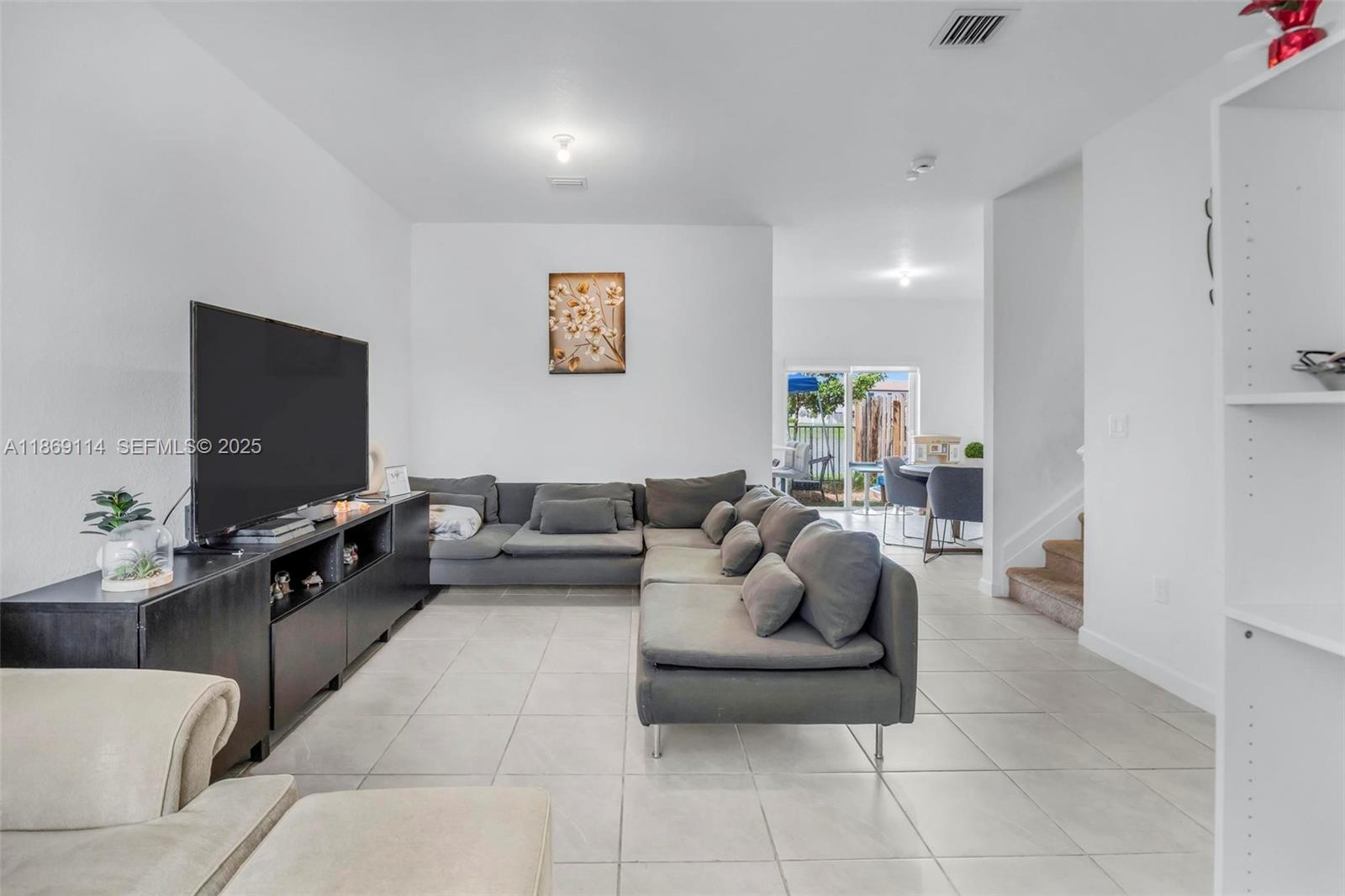 12774 Northwest 22nd Place Miami, FL 33167 - Photo 2 of 32 a living room with furniture and a flat screen tv