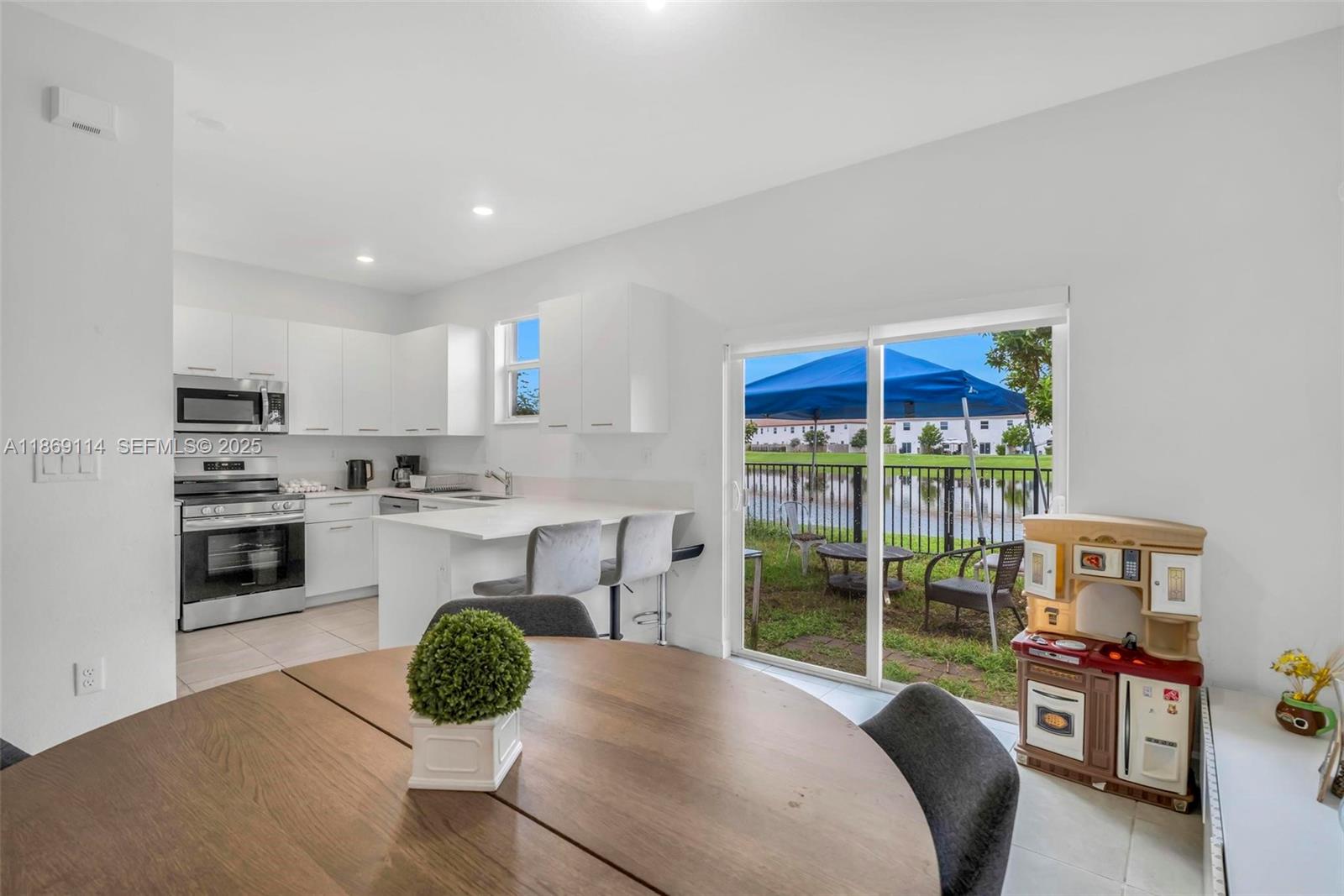12774 Northwest 22nd Place Miami, FL 33167 - Photo 6 of 32 a kitchen with stainless steel appliances granite countertop a stove a sink and a refrigerator