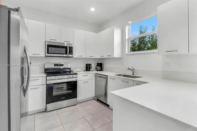 a kitchen with stainless steel appliances a stove microwave and sink